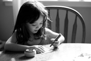 young child writing to illustrate reclaiming our creativity in a blogpost by Yang-May Ooi